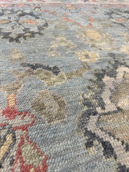 Kennedy Turkish Oushak rug, hand-knotted wool with a light blue base, ivory border, and navy, light gold, light green, and raspberry accents