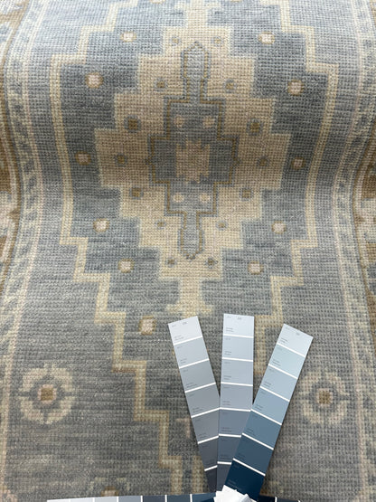 Susie modern Oushak rug, soft gray-blue with a warm brown border and olive, sage green, tan, and cool gray accents