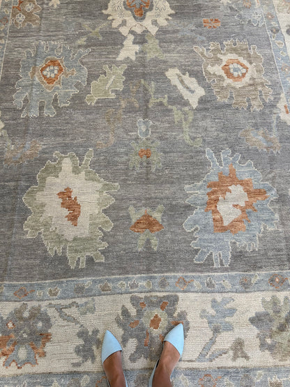 Margaret Turkish Oushak rug, hand-knotted wool with a slate gray foundation, cream border, and light green, pale blue, warm tan, and muted orange accents