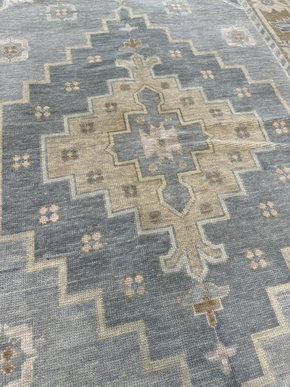 Susie modern Oushak rug, soft gray-blue with a warm brown border and olive, sage green, tan, and cool gray accents