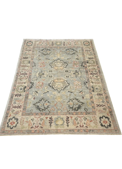 Kennedy light blue Turkish Oushak rug with an ivory border and navy, gold, green, and raspberry accents, hand-knotted wool