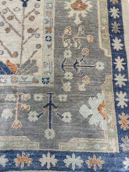 Sophia hand-knotted wool Turkish Oushak rug in ivory with gray border and orange, cobalt, and green tones
