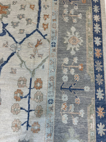 Sophia ivory Turkish Oushak rug with a gray border and orange, cobalt, light green, light blue, and tan accents, hand-knotted wool