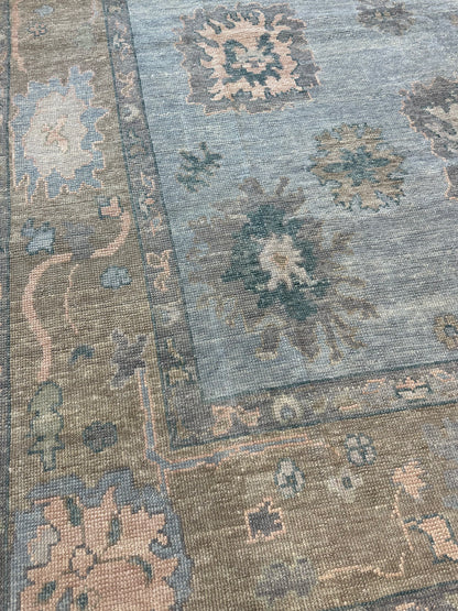 Juliet hand-knotted wool Turkish Oushak rug in light blue with tan border and pink, teal, and blue