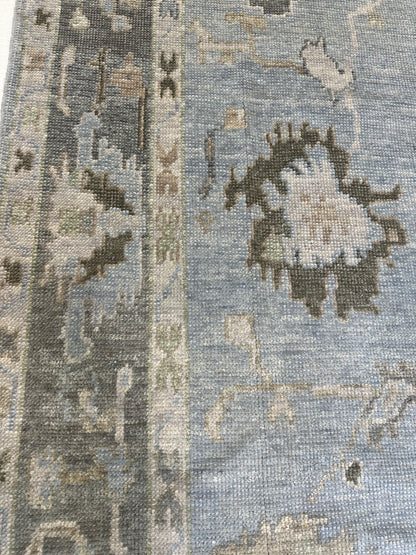 Josephine Turkish Oushak rug, hand-knotted wool with a light blue foundation, slate gray border, and chocolate brown, light green, tan, and cream accents