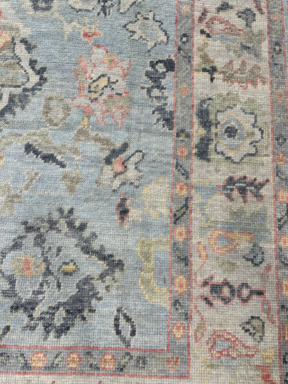 Kennedy light blue Turkish Oushak rug with an ivory border and navy, gold, green, and raspberry accents, hand-knotted wool