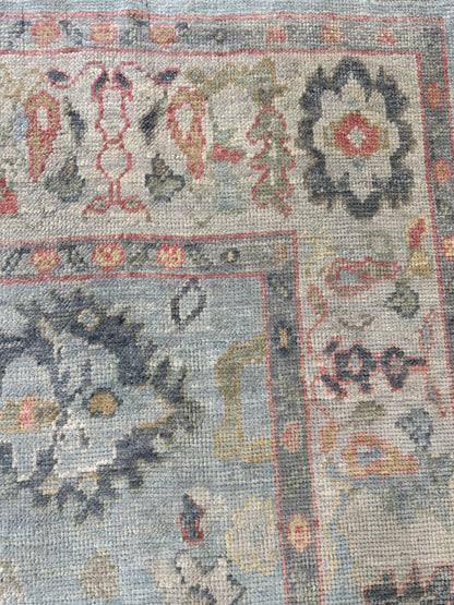 Kennedy Turkish Oushak rug, light blue with ivory border and navy, gold, green, and raspberry accents