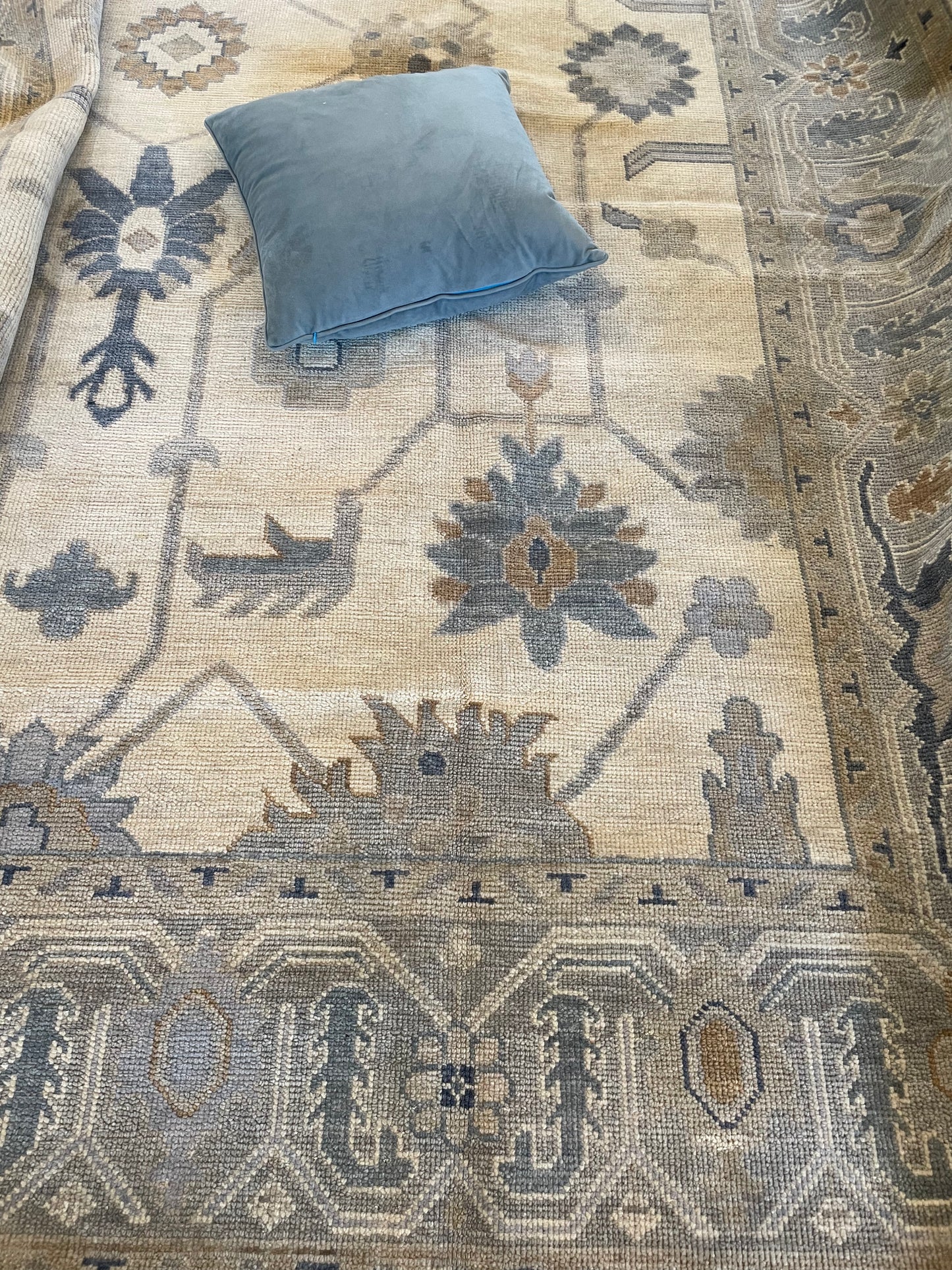 Cream and Blue Modern Oushak rug with blue pillow