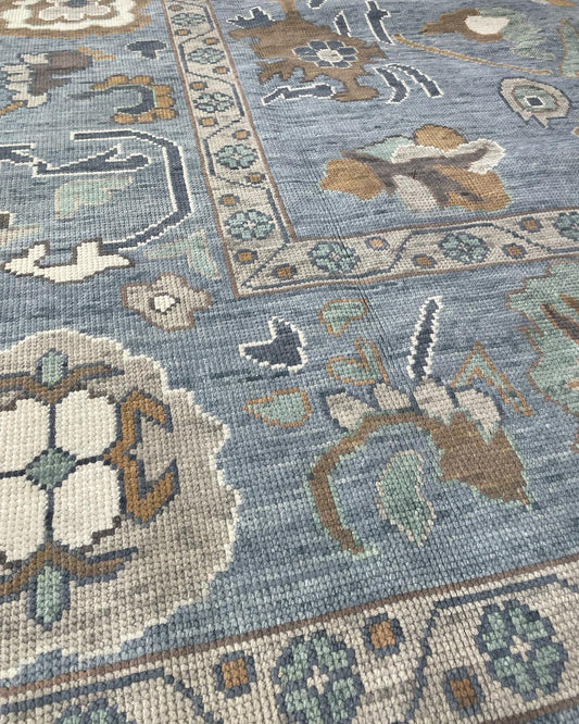 Mae Modern Blue Oushak Rug with afccents of green, brown, and cream