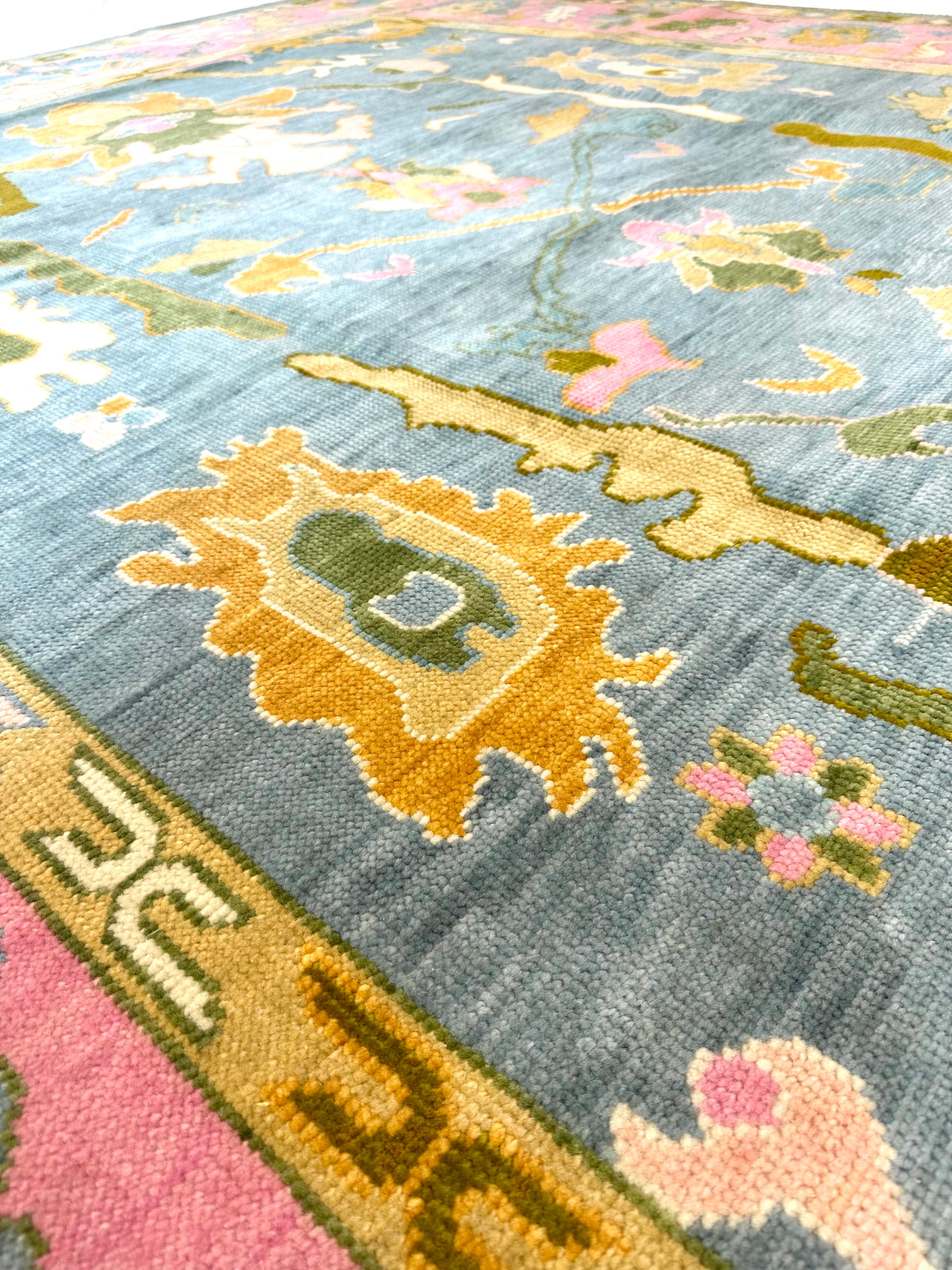 Addie Modern Oushak rug, medium blue, pink border, green, orange, tan, cream, chartreuse-olive — hand-knotted wool area rug