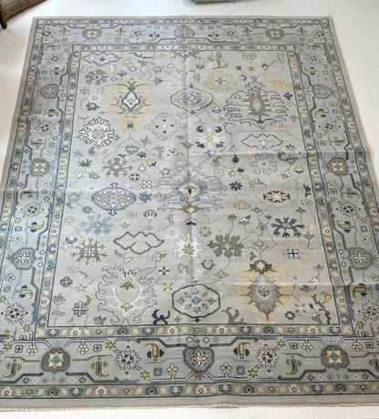 Margot modern Oushak rug, a gray center, light blue border, and mustard, green, cream, and navy accents