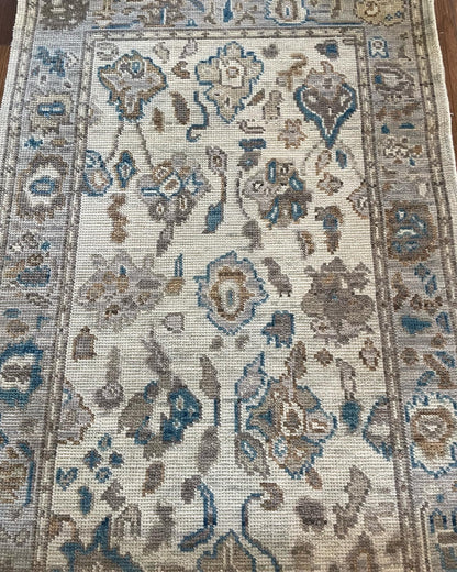 Ollie hand-knotted wool modern Oushak rug in cool gray with taupe border and cobalt, brown, and tan