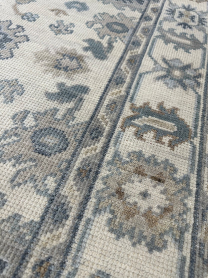 Emma Modern Oushak rug styled in a room, cream, gray, soft cream, calming blues, hand-knotted wool