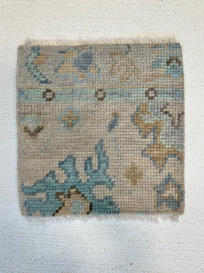 Maggie modern Oushak rug, a warm gray foundation, cool gray border, and aqua and turquoise accents