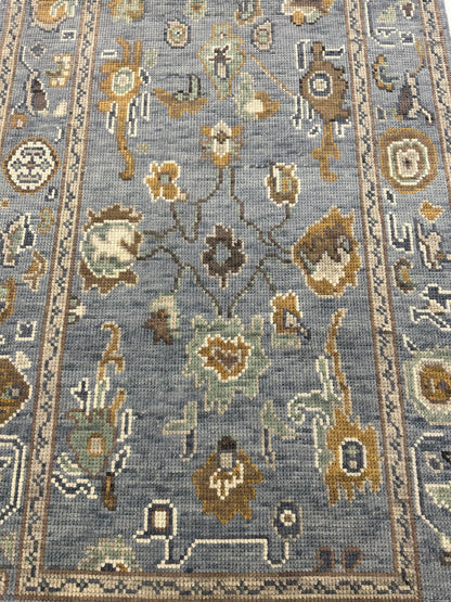 Mae hand-knotted wool modern Oushak rug in a blue-gray foundation and cream, mustard, sage, and brown accents