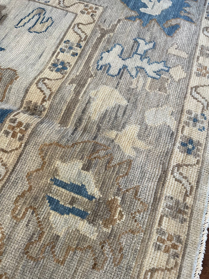 Ollie modern Oushak rug, cool gray with taupe border and cobalt blue, cream, brown, and tan accents
