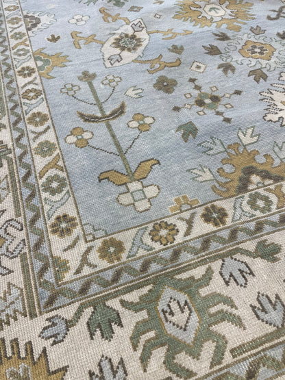 Katherine hand-knotted wool modern Oushak rug in light blue with cream, tan, ochre, and green