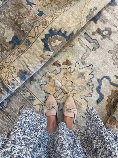 Ollie modern Oushak rug, hand-knotted wool with a cool gray foundation, taupe border, and cobalt blue, cream, brown, and tan accents