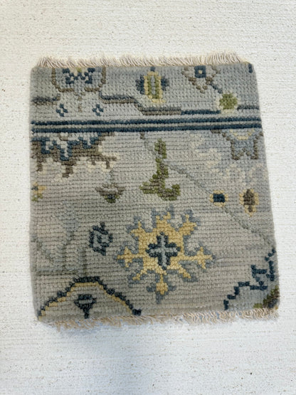 Margot modern Oushak rug with a gray center, light blue border, and mustard, green, cream, and navy accents, hand-knotted wool