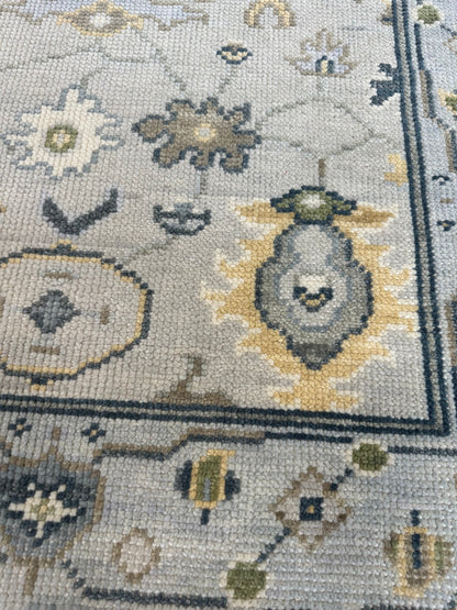 Margot modern Oushak rug, a gray center, light blue border, and mustard, green, cream, and navy accents