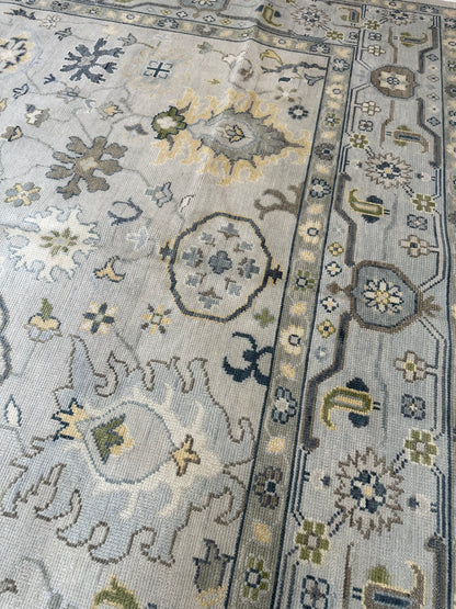 Margot hand-knotted wool modern Oushak rug in a gray center, light blue border, and mustard, green, cream, and navy accents