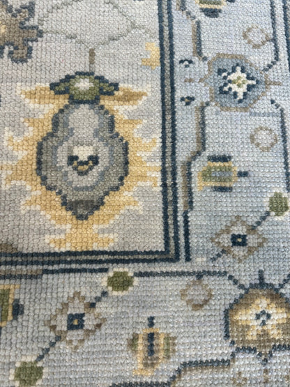 Margot modern Oushak rug, hand-knotted wool with a gray center, light blue border, and mustard, green, cream, and navy accents