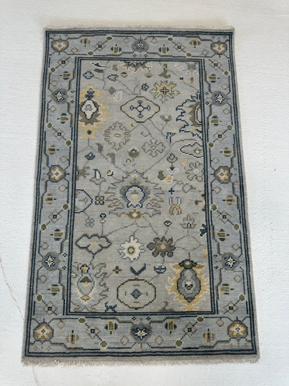 Margot modern Oushak rug, hand-knotted wool with a gray center, light blue border, and mustard, green, cream, and navy accents