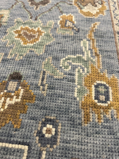 Mae modern Oushak rug, a blue-gray foundation and cream, mustard, sage, and brown accents