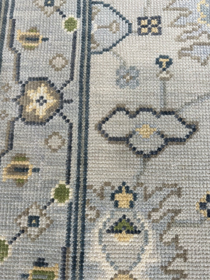 Margot hand-knotted wool modern Oushak rug in a gray center, light blue border, and mustard, green, cream, and navy accents